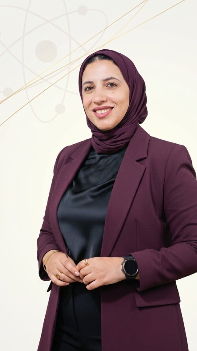 فاطمة سالم، فيزيائية، واقفة بذراعين متقاطعتين